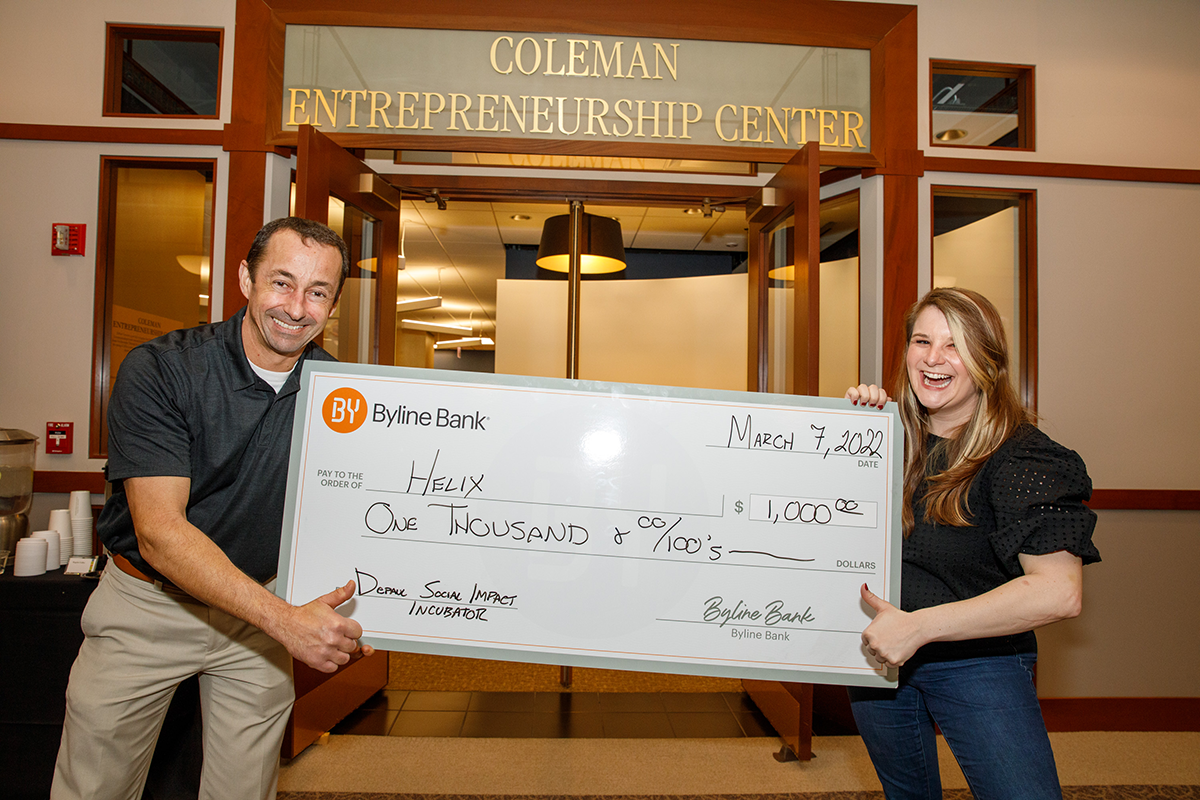 Stephen Ball, senior vice president at Byline Bank, presents a check to Caitlin Botsios, co-founder and executive director of Helix Chicago, a Chicago-based nonprofit that provides jobs to at-risk youth and in-school programming.