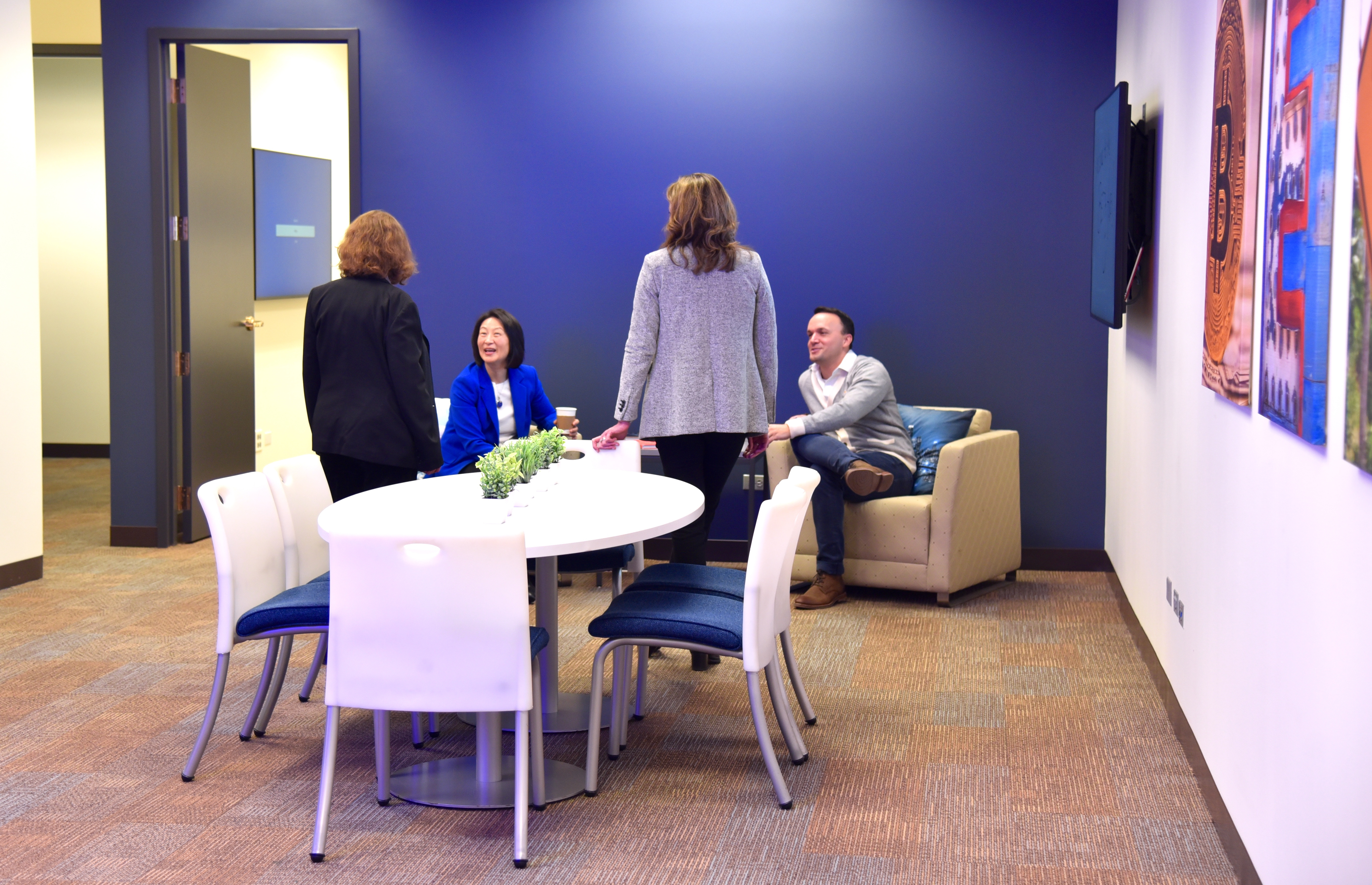A group of faculty gathers in a collaborative space