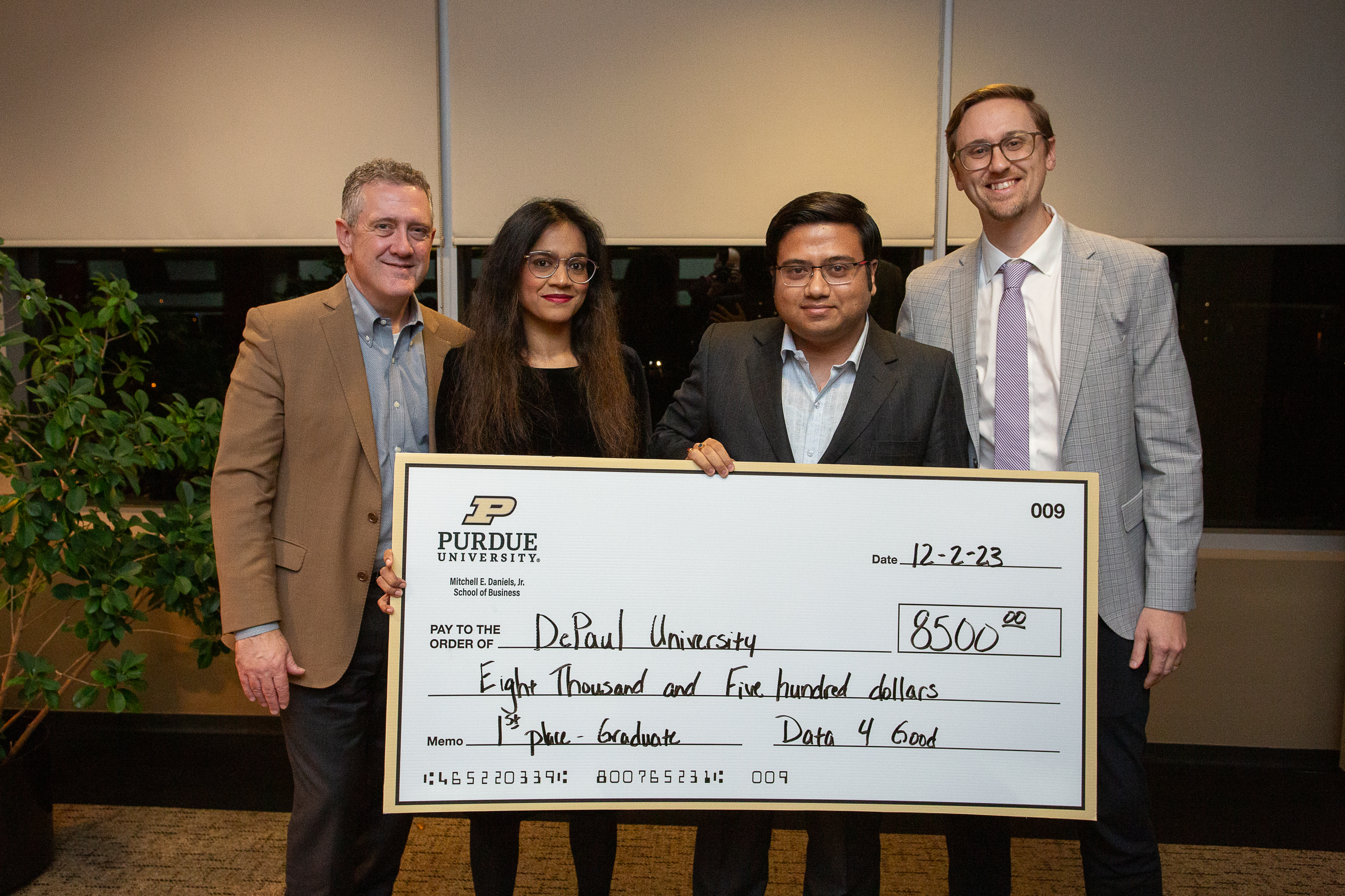 The winners of the Data4Good competition hold up a ceremonial check