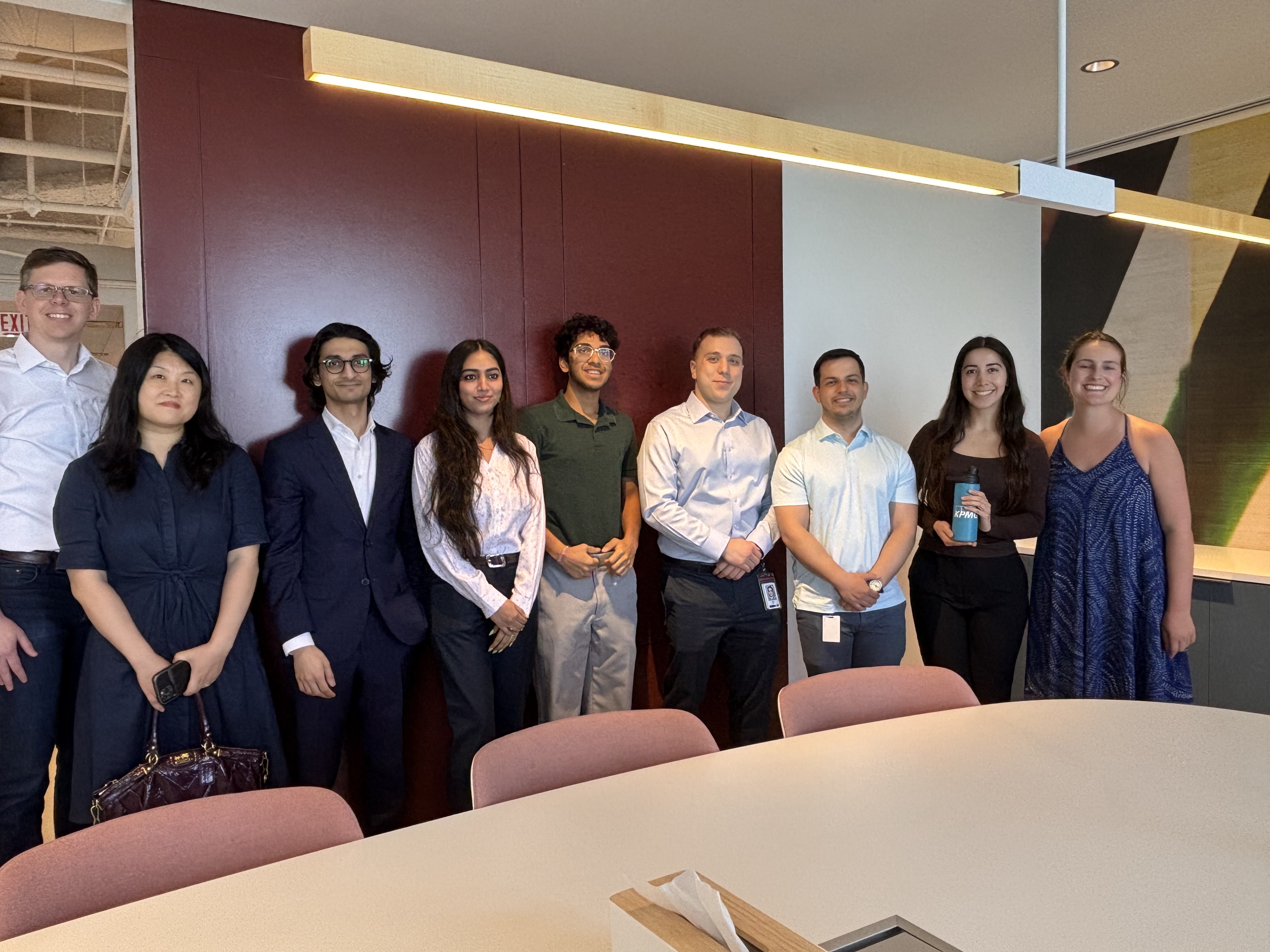 A group of students in business casual in a modern office setting